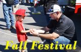 Prospective Lemoore Volunteer Fireman Ethan Decker gets some advice from Lemoore firemen Matt Moreno at Sunday's Fall Festival. 